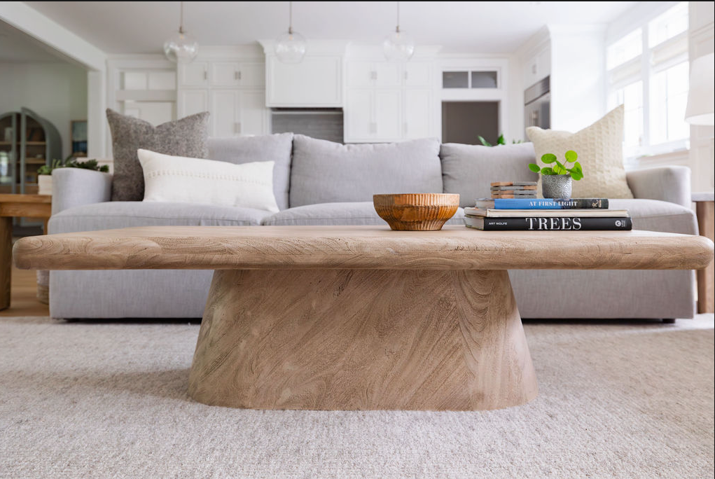 Living room with a modern wooden coffee table in front of a sofa.