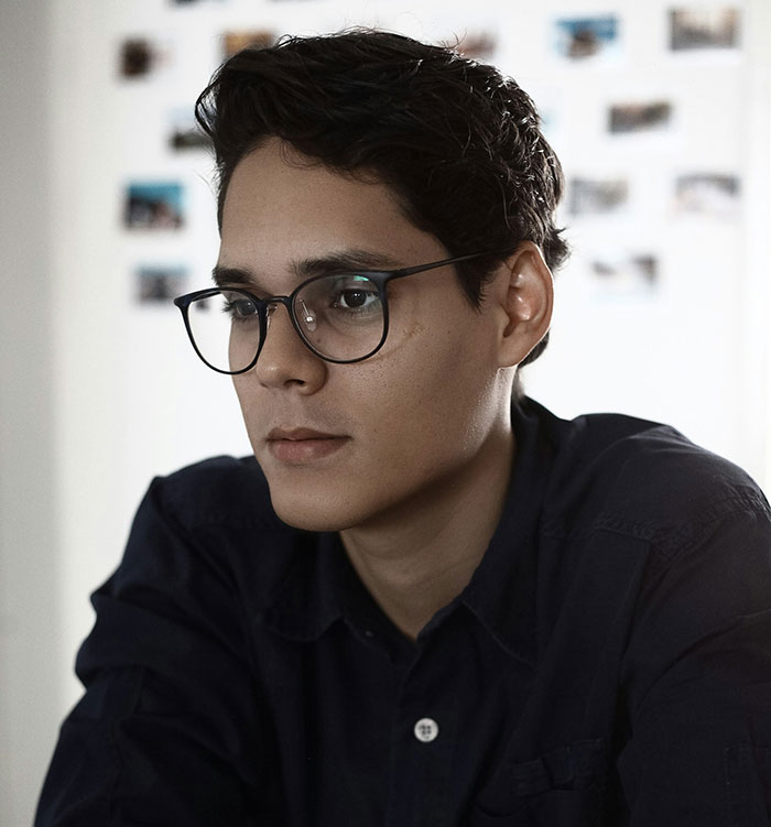 Young man wearing glasses focused on a screen, representing weirdly hilarious images to improve your feed and mood.