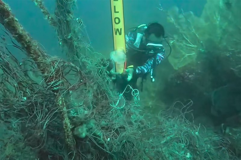 A diver from Mu Ko Similan National Park clears a mass of netting and ropes from abandoned fishing gear entangled in sea‑fan corals off Koh Payan (Similan No.3) in Phangnga province on Thursday. (Screenshots from video made by Mu Ko Similan National Park)