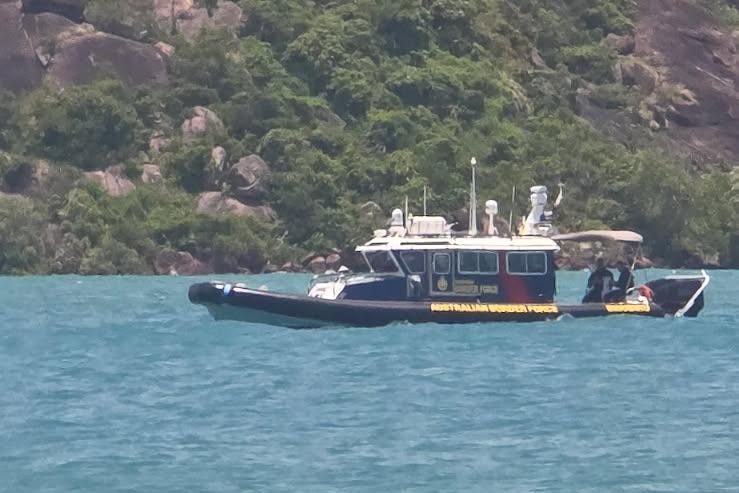 A patrol boat on the water with an island in the background