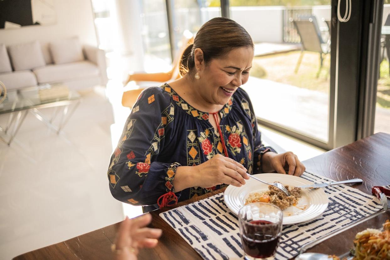 mature latin woman eating a traditional mexican food at home