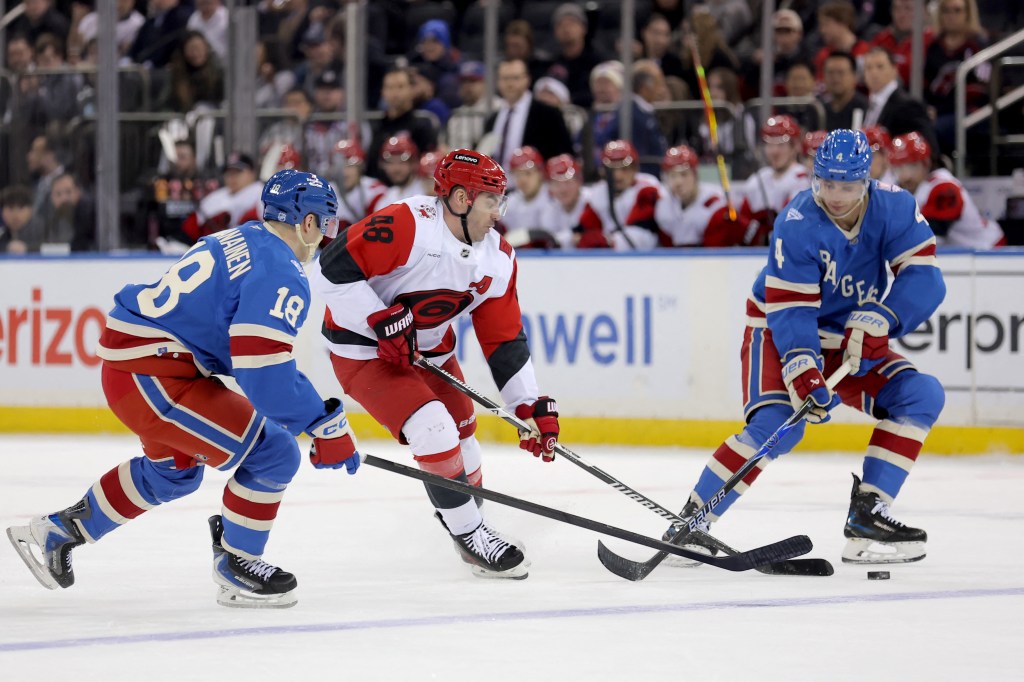 Carolina Hurricanes player Jordan Martinook (48) battles for the puck against New York Rangers defensemen Urho Vaakanainen (18) and Braden Schneider (4).