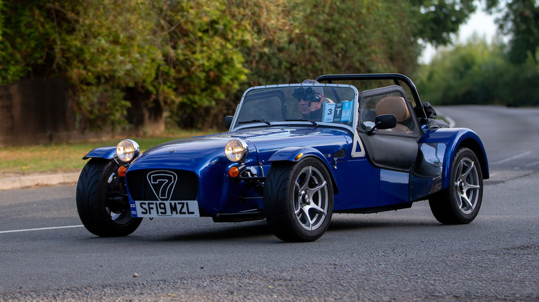 A blue Caterham 7 on a road