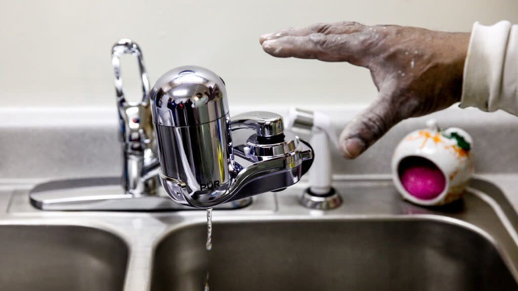 A person installing a water filter.