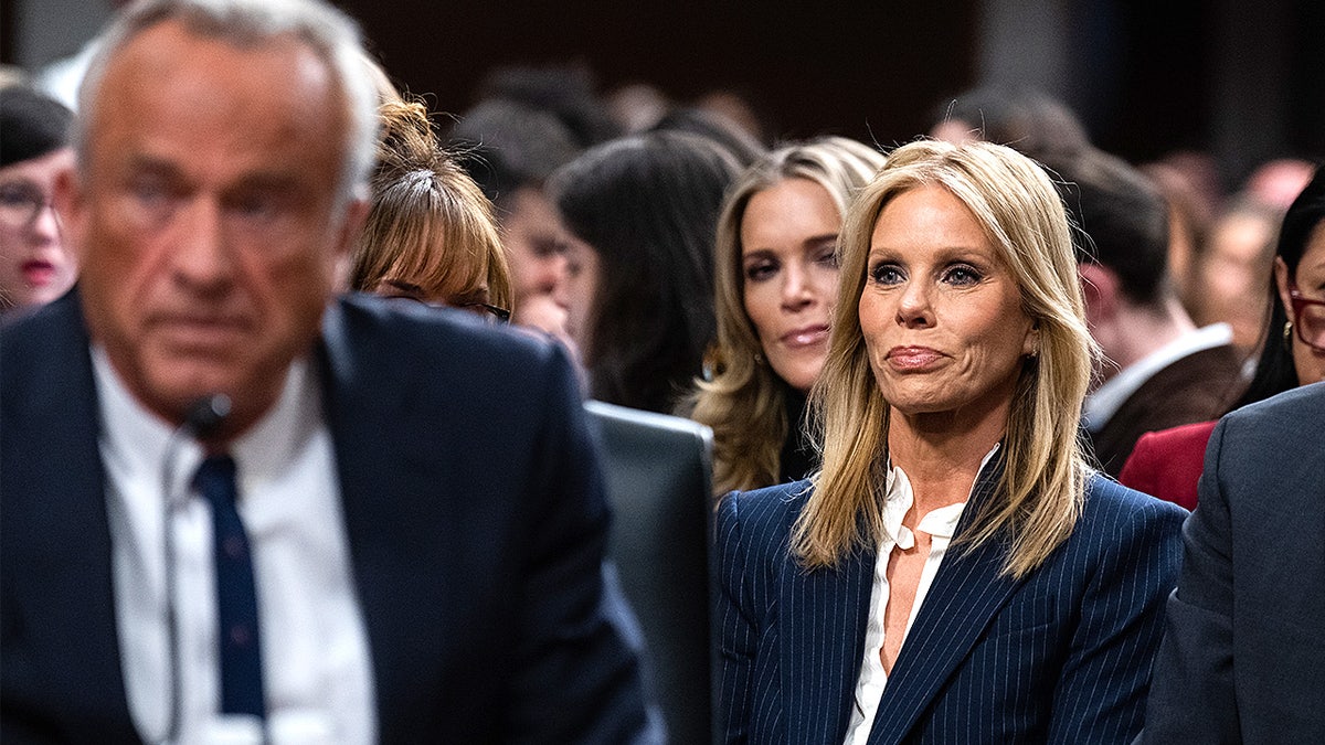 Robert F. Kennedy Jr. sits beside his wife Cheryl Hines as he testifies during a Senate committee hearing.
