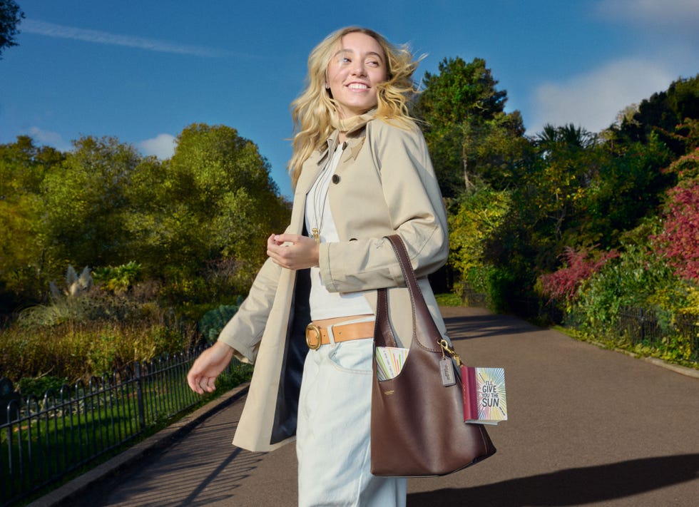 person walking in a park with a handbag