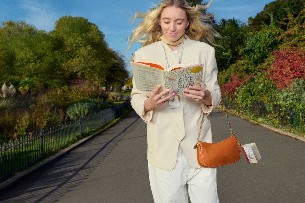 individual reading a book while walking