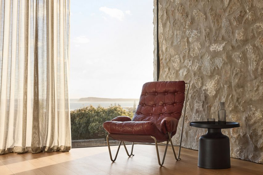 Red leather lounge chair in a room with stone walls