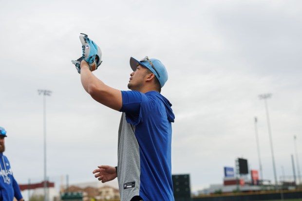 Seiya Suzuki looks at his glove during the first day of the Cubs full-squad workout at spring training at Sloan Park on Feb. 16, 2026, in Mesa, Ariz. (Armando L. Sanchez/Chicago Tribune)