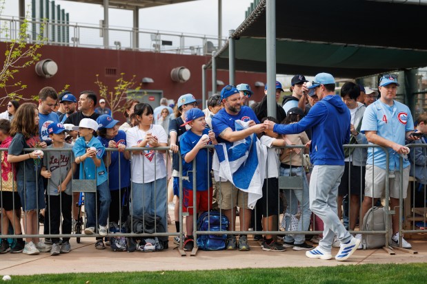 Manager Craig Counsell signs autographs for fans during the first day of the Cubs full-squad workout at spring training at Sloan Park on Feb. 16, 2026, in Mesa, Ariz. (Armando L. Sanchez/Chicago Tribune)
