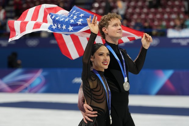 Silver medalists Madison Chock and Evan Bates of the United States skate with their medals after competing in the ice dancing free skate at the 2026 Winter Olympics, on Wednesday, Feb. 11, 2026, in Milan. (AP Photo/Francisco Seco)