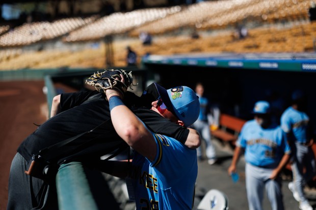 Former White Sox first baseman and Milwaukee Brewers first baseman Andrew Vaughn (28) hugs Chicago White Sox photographer Darren Georgia before playing the Chicago White Sox in a Cactus League game at Camelback Ranch on Sunday, Feb. 22, 2026, in Glendale, Ariz. (Armando L. Sanchez/Chicago Tribune)