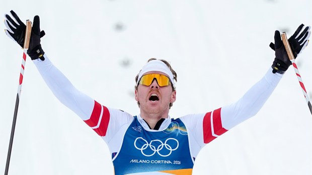 Ben Ogden of the United States crosses the finish line to win the silver medal in the cross-country skiing men's sprint classic at the 2026 Winter Olympics on Tuesday, Feb. 10, 2026, in Tesero, Italy. (AP Photo/Matthias Schrader)