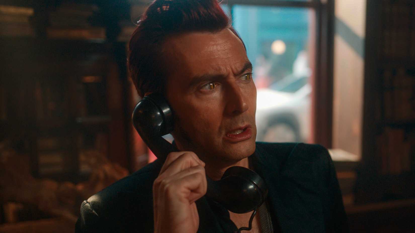 David Tennant as Crowley looking worried while holding the phone in Good Omens