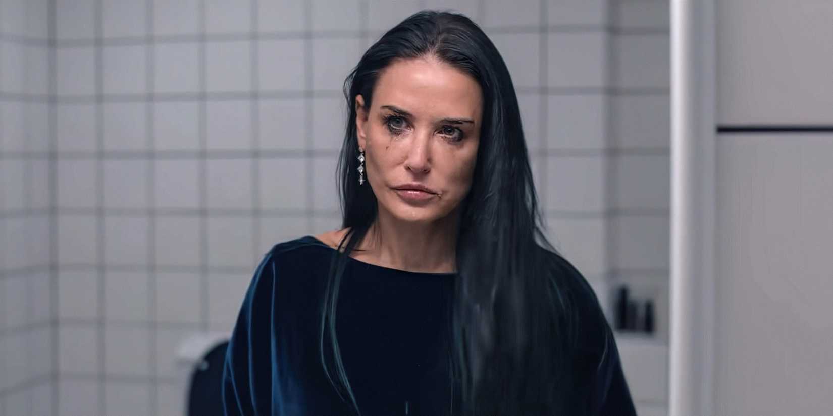 Demi Moore lloking in the mirror while crayin in The Substance