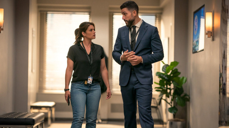 Maggie Bell (Missy Peregrym) and O.A. Zidane (Zeeko Zaki) speak while walking down a hallway in FBI