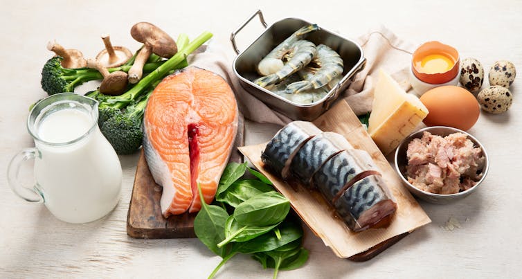 An assortment of vitamin D-rich foods, including salmon and sardines, egg yolks and milk.