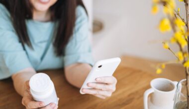 woman holding white prescription bottle in right hand and smartphone on the left hand