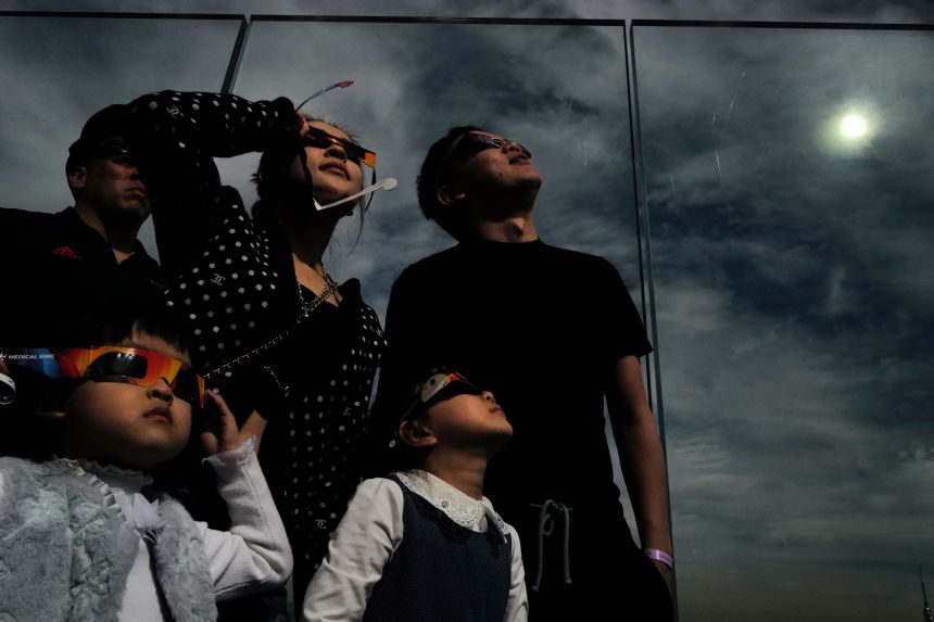 A group watches the total solar eclipse in New York City on April 8, 2024, as the path of totality moved across North America.