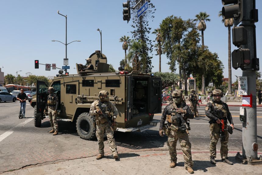 Federal immigration agents stood outside an armored vehicle near MacArthur Park in Los Angeles, California, on July 7, 2025.