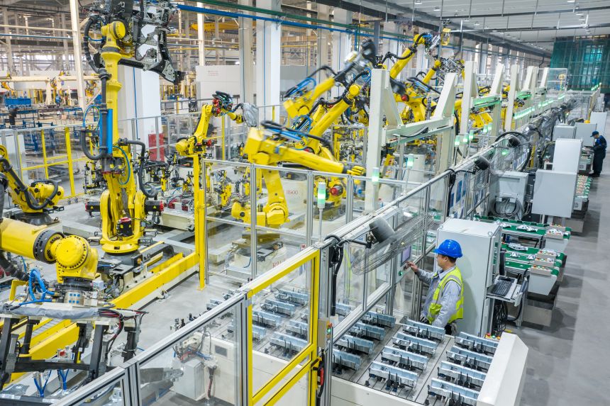 Robotic arms and employees work on the automated production line of new energy vehicle components at a workshop in Changxing County, Huzhou City, Zhejiang Province of China, on December 11, 2025
