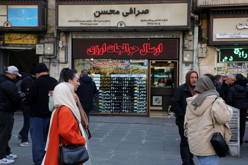People are seen standing in front of a currency exchange office as Iranâs national currency continues to lose value in Tehran, Iran, on January 28, 2026.