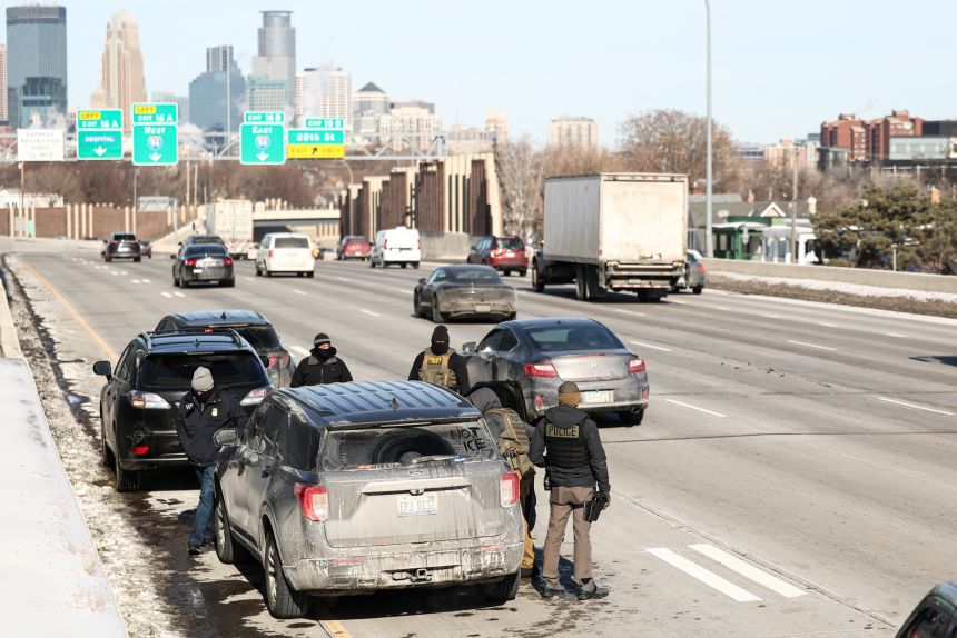 Federal agents pull over a car after an alleged collision with them on the highway in Minneapolis on February 3, 2026.