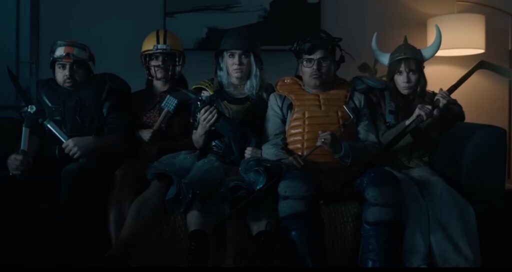 group of random looking people wearing makeshift armor and carrying found objects as weapons