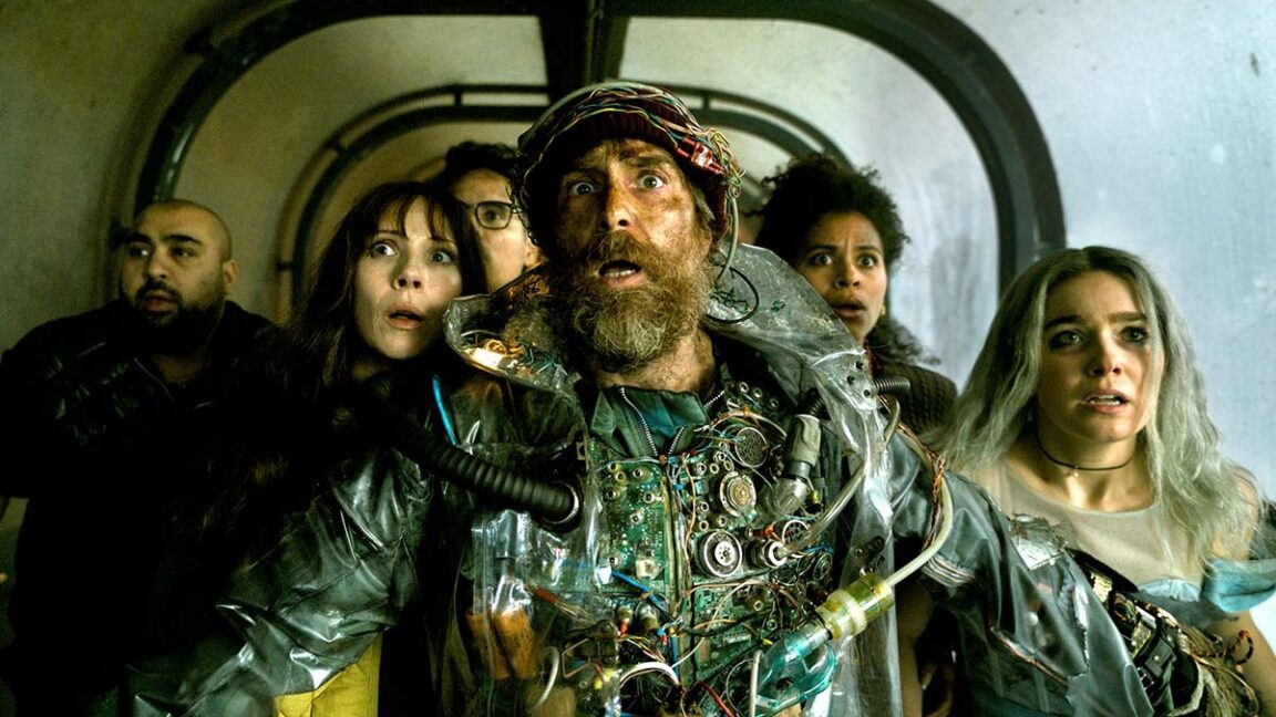 ragtag group of people in makeshift battle gear looking shocked at something in front of them