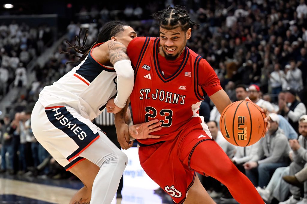 St. John's forward Bryce Hopkins (23) is guarded by UConn guard Solo Ball in a college basketball game.