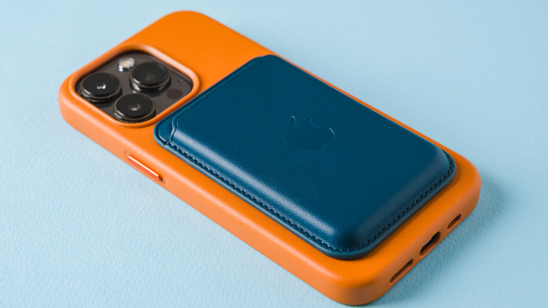 A blue MagSafe wallet attached to an orange iPhone 17