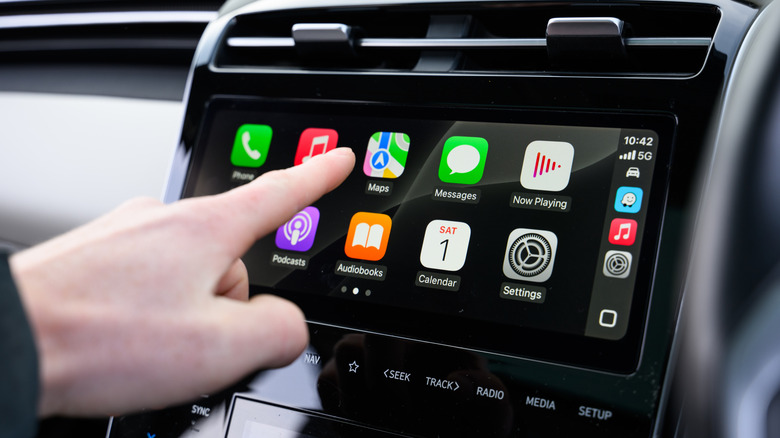 Man about to touch Apple Maps in Apple CarPlay