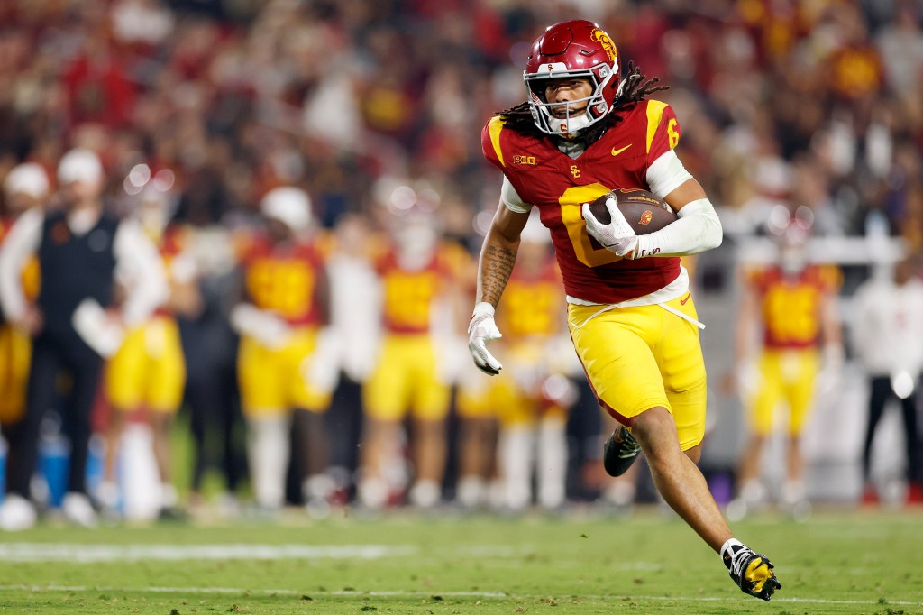 Makai Lemon #6 of the USC Trojans runs with the ball during a football game.