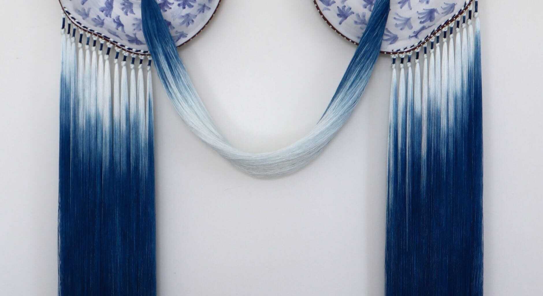 A blue-and-white, ceramic-and-fiber wall artwork by Nicole McLaughlin
