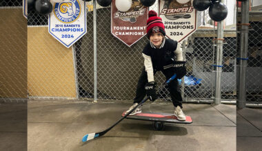 boy playing hockey on balance board