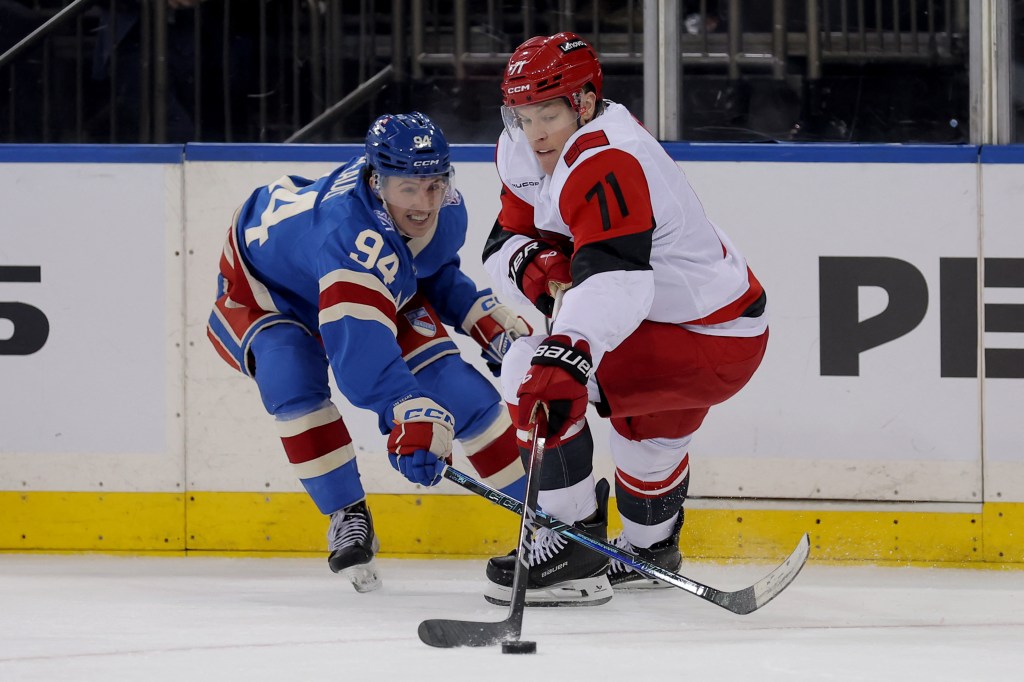 New York Rangers right wing Gabe Perreault (94) fights for the puck against Carolina Hurricanes left wing Taylor Hall (71).