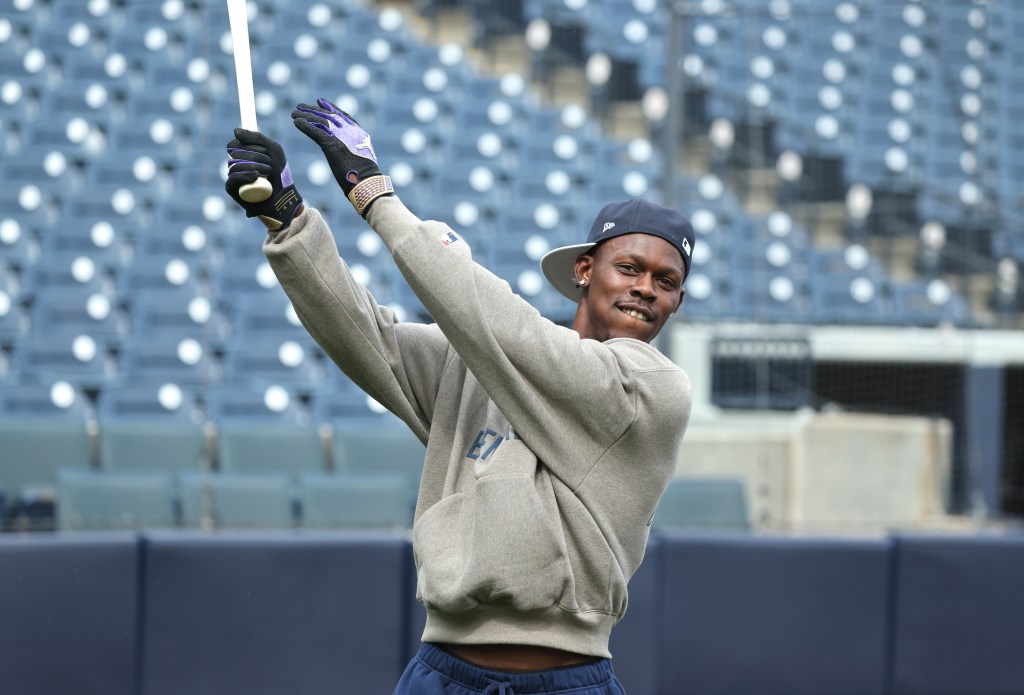 New York Yankees second baseman Jazz Chisholm Jr. #13 in batting gloves and sweatshirt, holding a baseball bat during spring training.