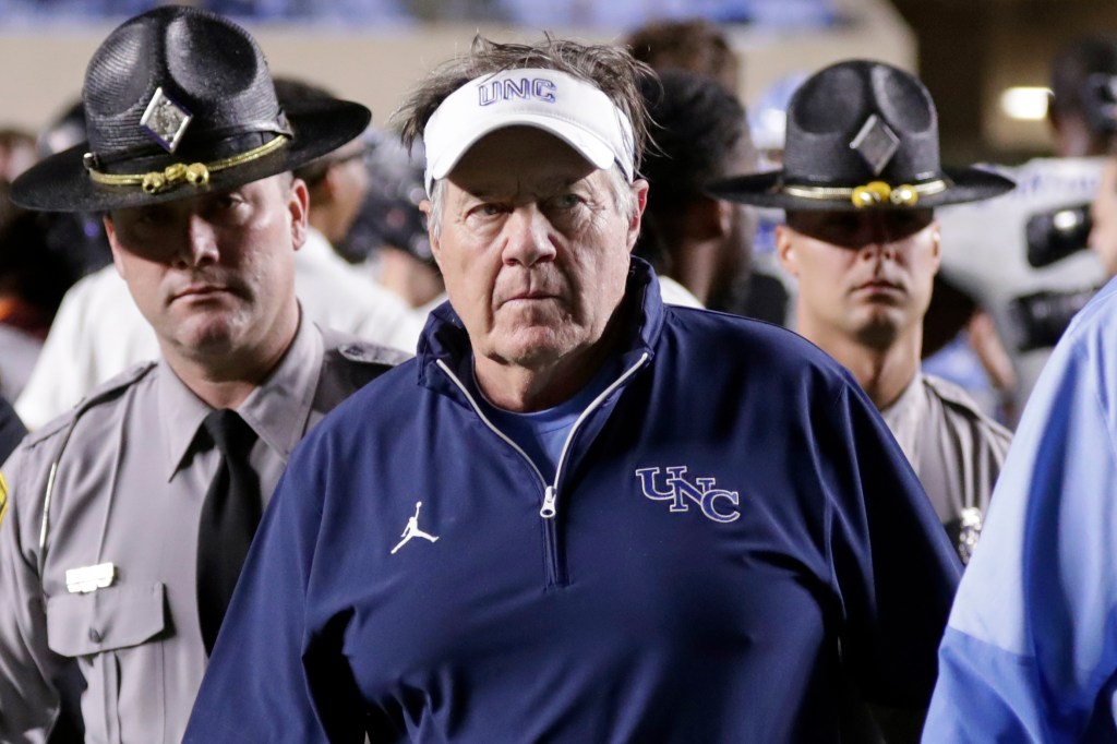 North Carolina coach Bill Belichick walks off the field after losing a college football game.