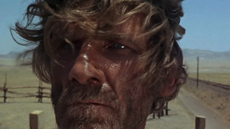 Close-up of Knuckles (Al Mulock) near a train track in Once Upon a Time in the West