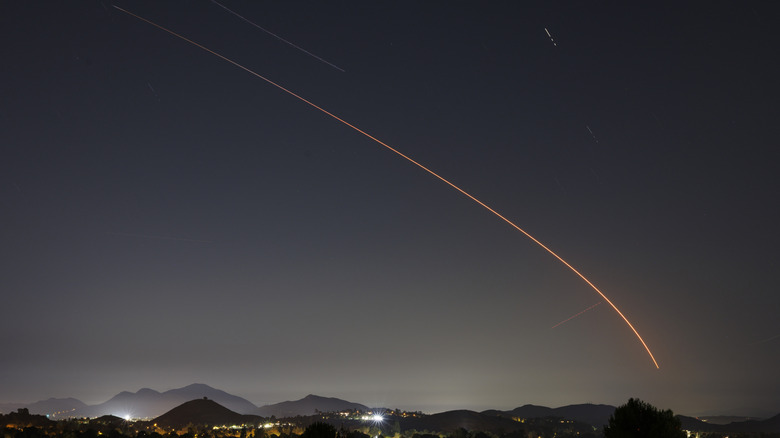 In a long exposure photo, a SpaceX Falcon 9 rocket carrying a payload of 24 Starlink internet satellites soars into space after launching from Vandenberg Space Force Base on August 30, 2025, seen from Thousand Oaks, California.