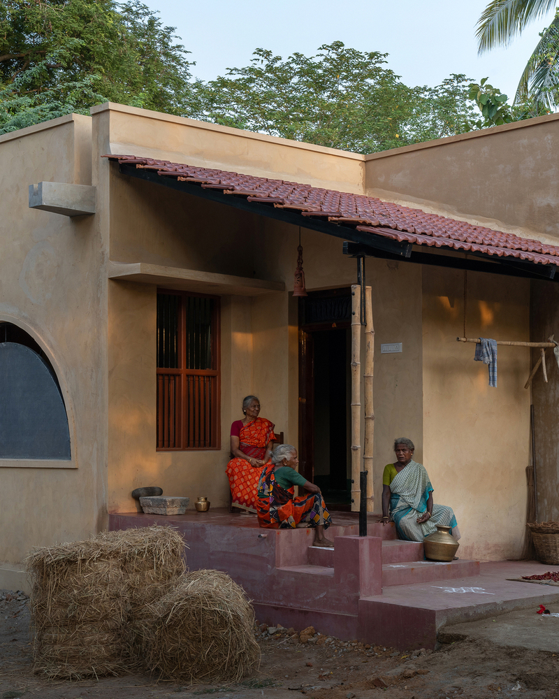 thousands of reclaimed bricks shape rural residence amid agricultural fields in india
