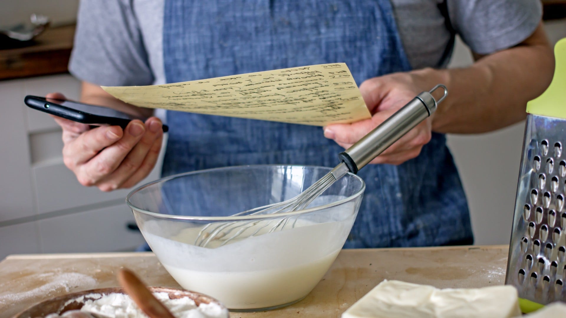 man who has a recipe written on paper and keeps photo albums