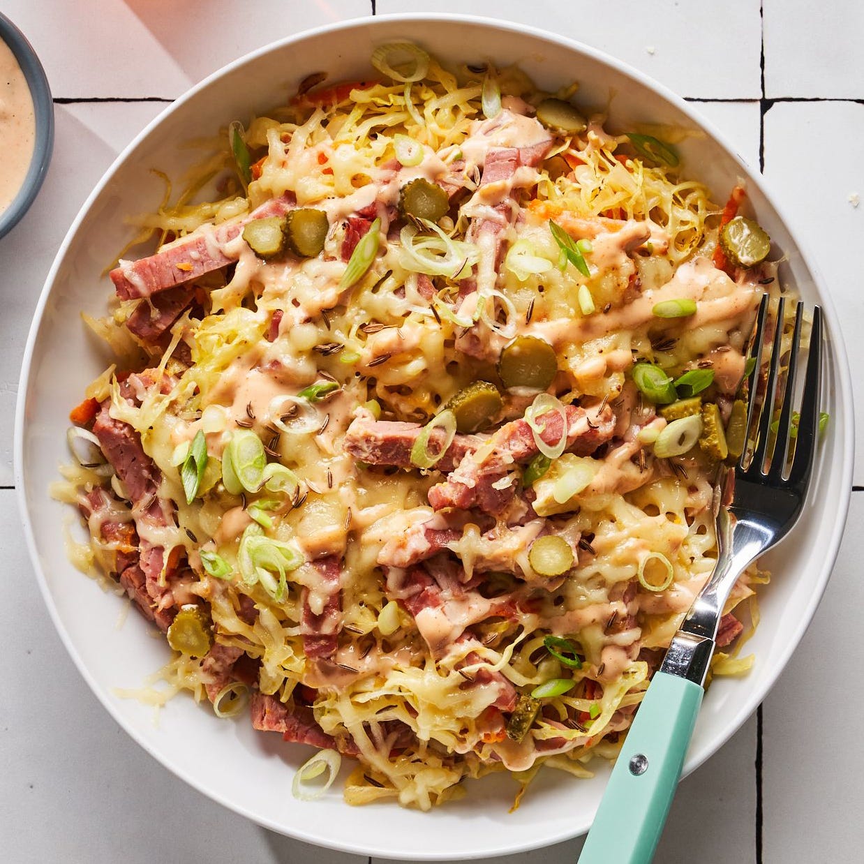 corned beef, cabbage, sauerkraut, cheese, and russian dressing in a bowl