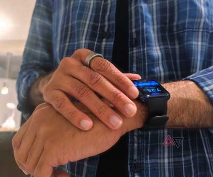 A person wearing a RingConn Smart Ring and Oppo Watch, checking the time