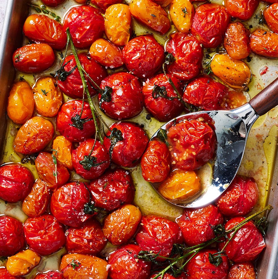 roasted tomatoes on a sheet tray with flaky sea salt and black pepper
