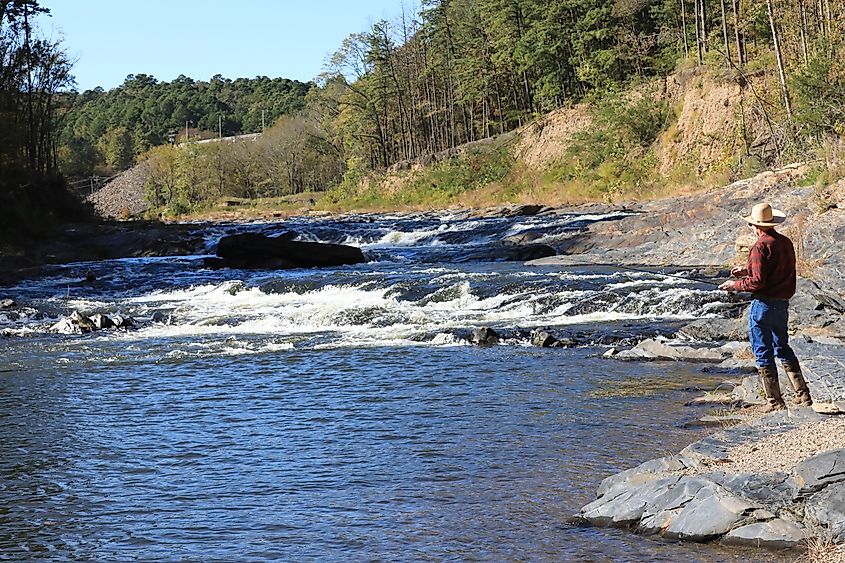 A man trout fishing in the Mountain Fork River at Beavers Bend State Park in Broken Bow, Oklahoma.