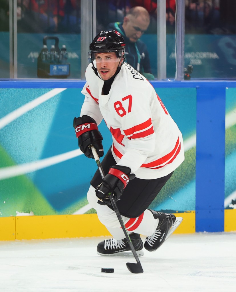 Sidney Crosby of Team Canada skates with the puck during an ice hockey game.