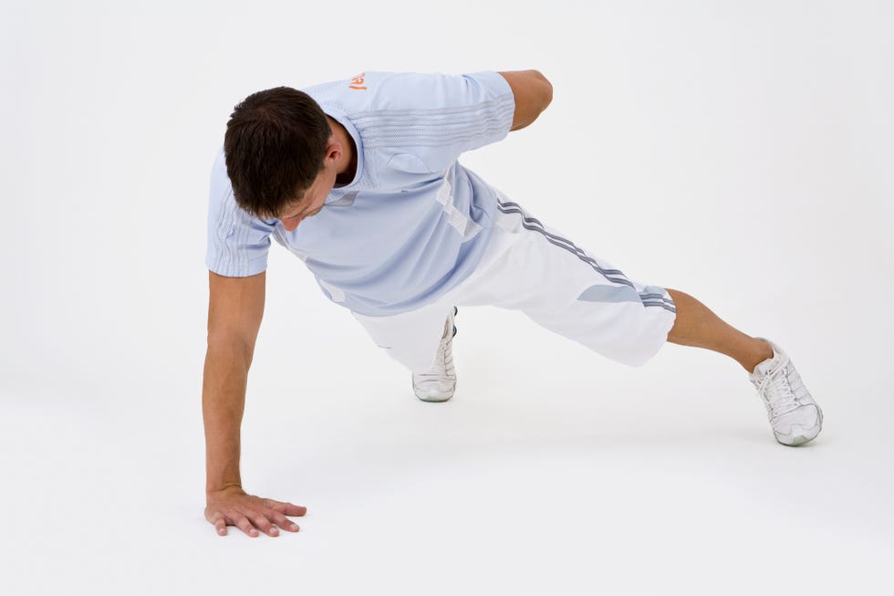 A man doing a one-arm push-up person performing a fitness exercise