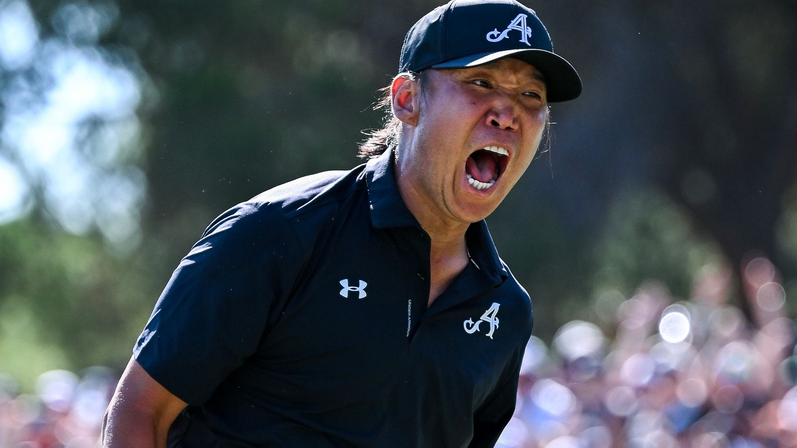 Anthony Kim roars in celebration after sinking his winning putt on the 18th hole