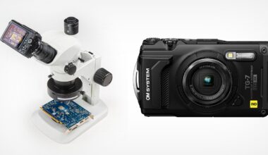 A digital camera is mounted on a white microscope examining a circuit board. Next to it, there is a black OM System TG-7 compact digital camera on a white background.